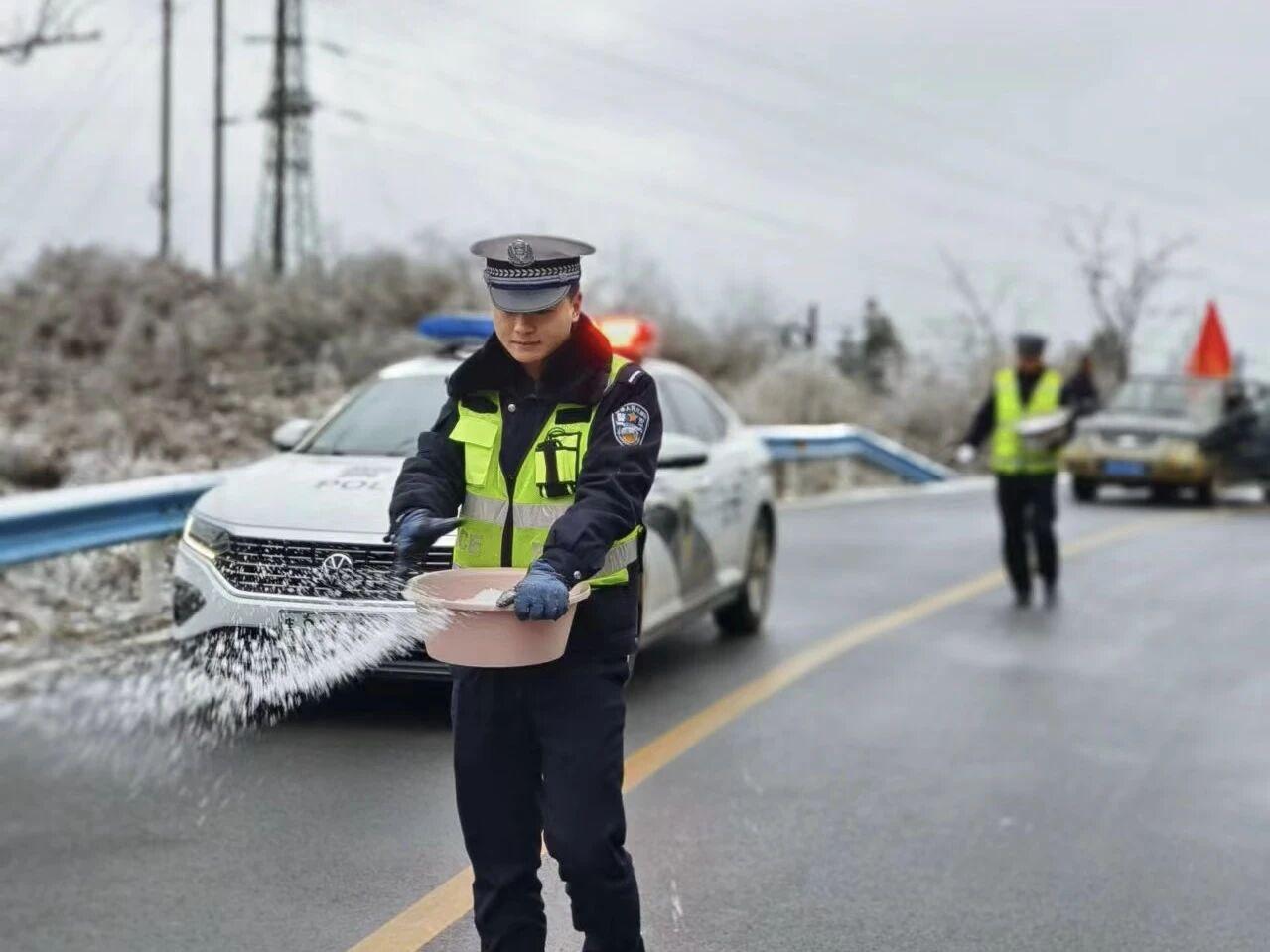 圖1民警在轄區(qū)結(jié)冰路段開展撒鹽除冰防凍工作。.jpg