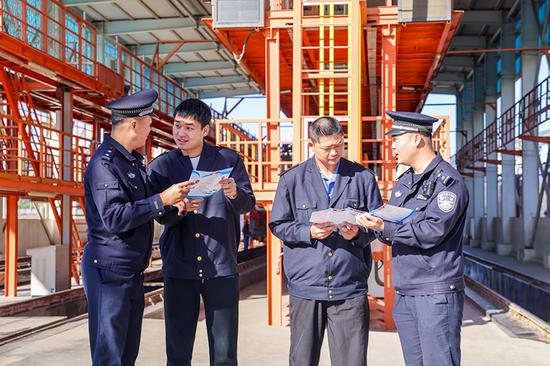 刑警支隊(duì)民警向企業(yè)職工發(fā)放宣傳資料并“一對(duì)一”講解電詐常識(shí)。謝仁古力·托呼提 攝